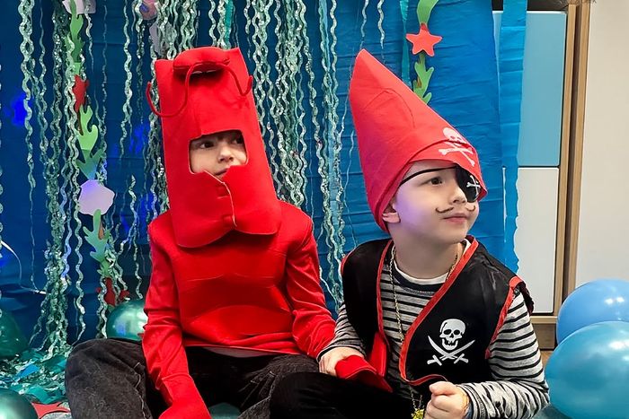 Dwoje dzieci w strojach karnawałowych podczas zabawy w teatr